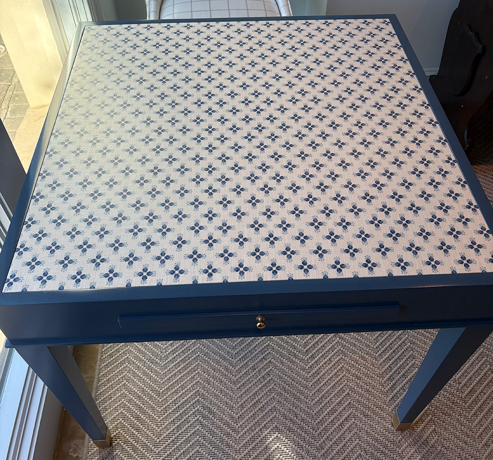 Taryn Game table with a blue and white patterned top in a room setting.