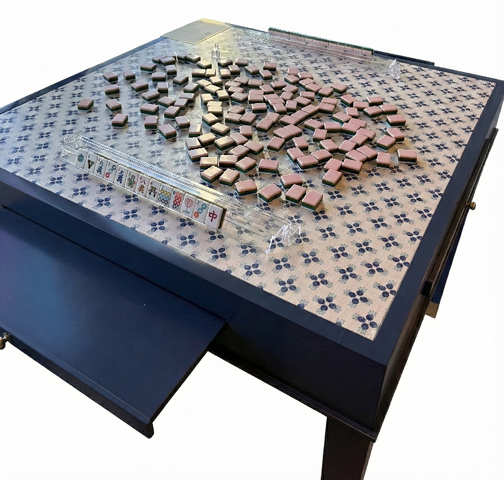 Mahjong game set on a folding table with tiles and pieces.