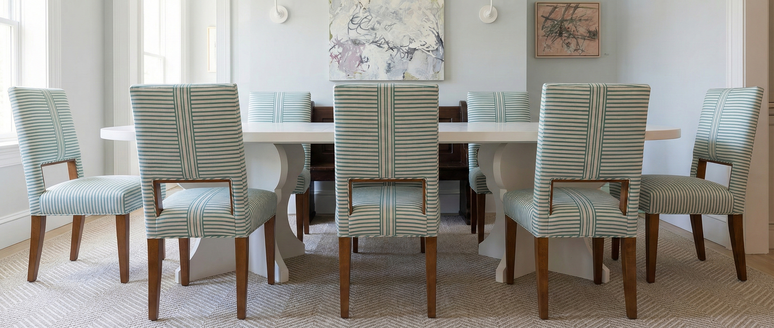 Dining room with a Louise table and striped chairs.
